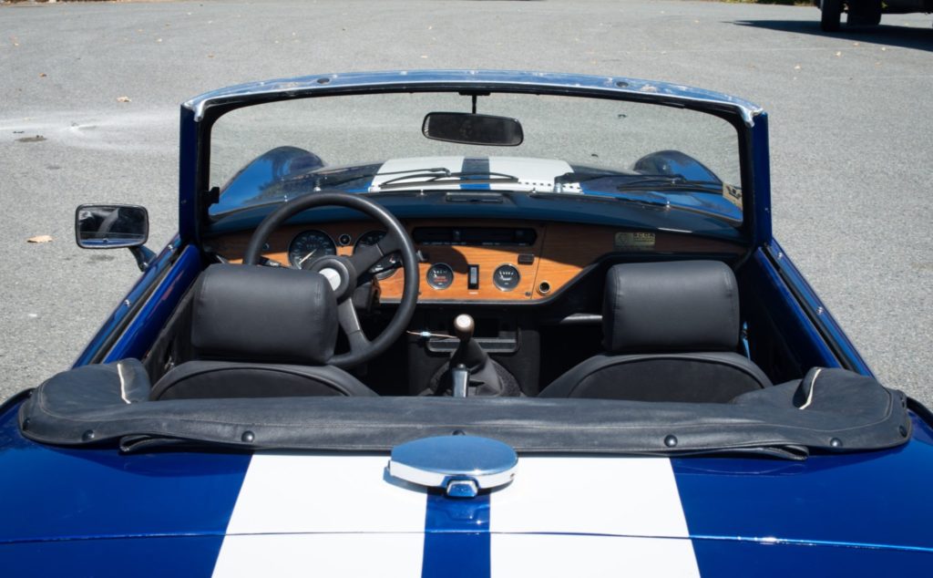 Overhead view of the black interior of a 1981 Triumph Spitfire Roadster with blue and white stipes